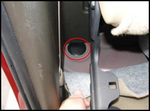 Rear cab mount bolt cover, under rear carpet